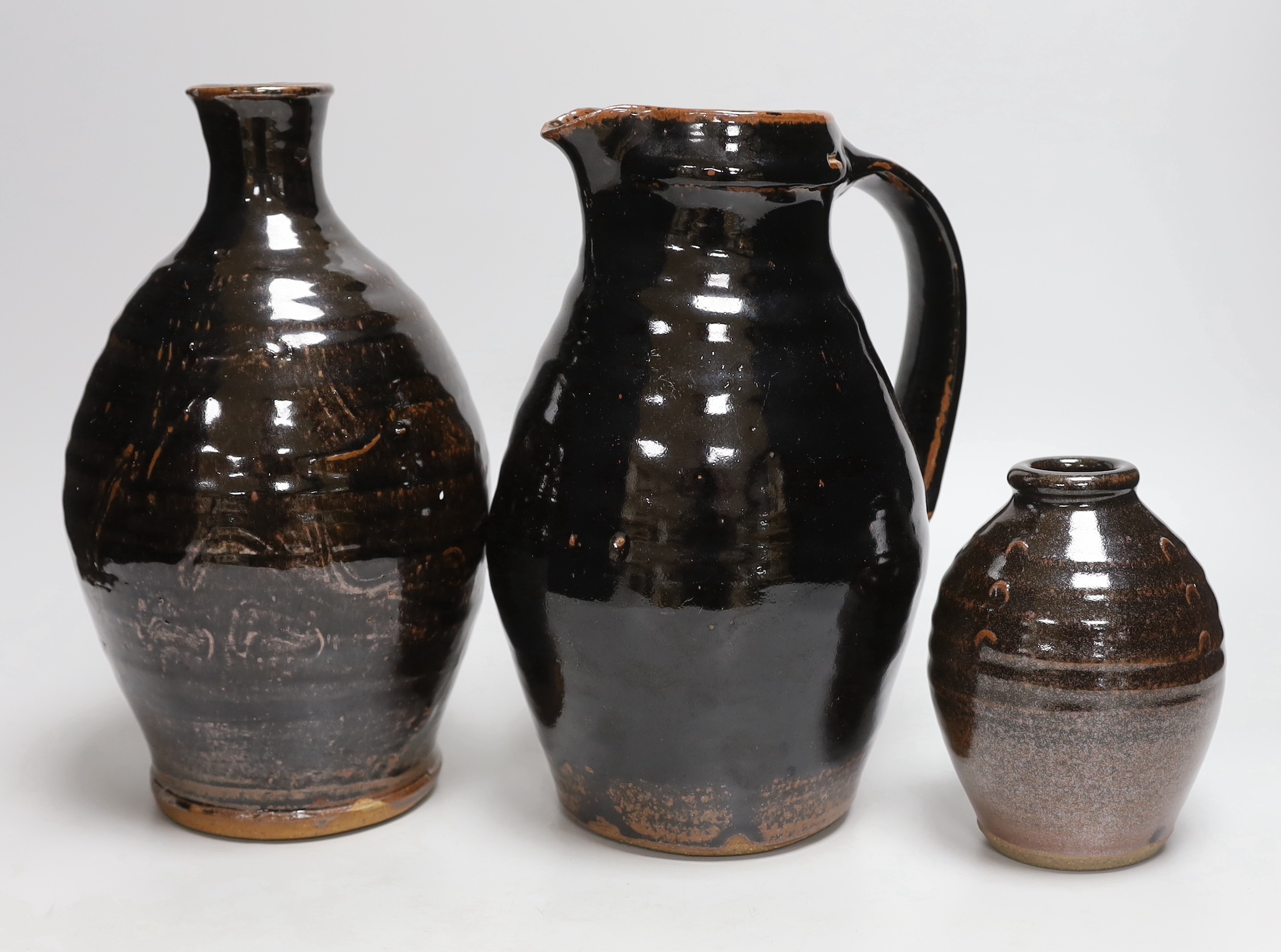Two green glazed dishes by Jack Kenny, two dark glazed vases, a similar jug and a small bowl, tallest 26cm high